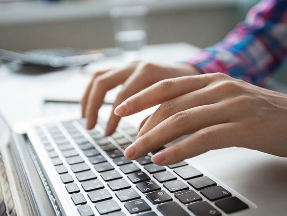 Mãos sobre o teclado Uma pessoa se senta diante do laptop e trabalha