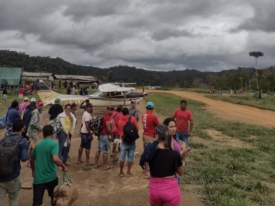 Garimpeiros esperam com a bagagem para deixar a terra dos Yanomami
