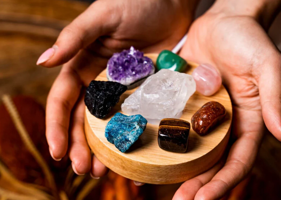 Various precious stones Várias pedras preciosas em uma bandeja de madeira segurada pelas mãos