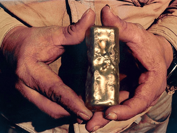 Um homem segura uma barra de ouro