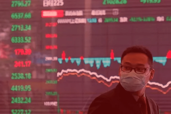 Um chinês com uma máscara cirúrgica em frente a um gráfico