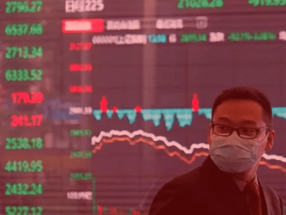 Covid-19 Um chinês com uma máscara cirúrgica em frente a um gráfico