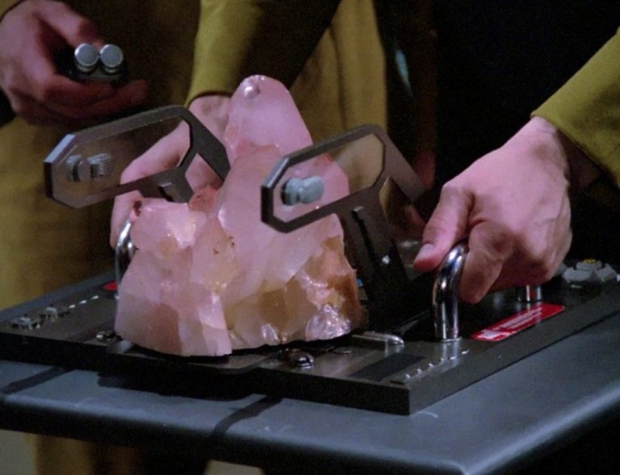 Um pedaço de dilithium em um prato. Uma pessoa está segurando o prato.