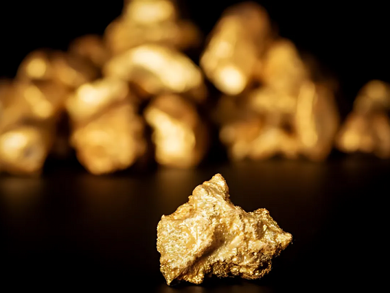 Ouro Uma peça de ouro em primeiro plano, mais atrás dela