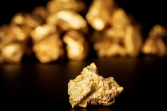 Uma peça de ouro em primeiro plano, mais atrás dela