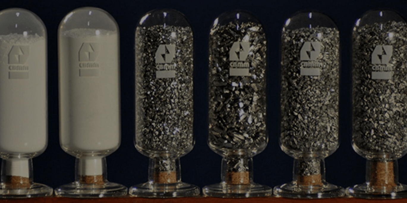 Grânulos de ferronióbio envasados em garrafas. As garrafas estão de cabeça para baixo.